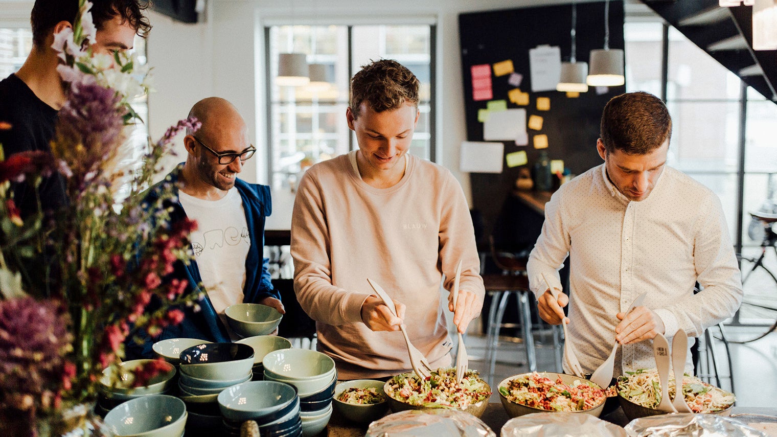 men taking food from dishes at work