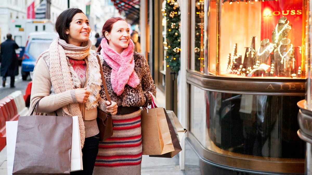 Women with shoopingbags looking at shopwindow.