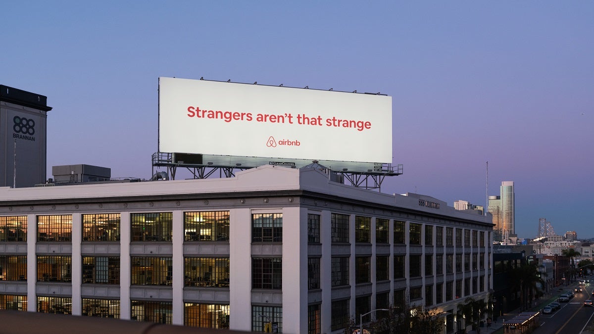 Billboard for AirBNB which says "Strangers aren't that strange"