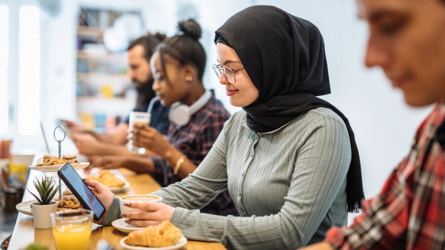 A young customer enjoys a digital experience on her mobile at a cafe