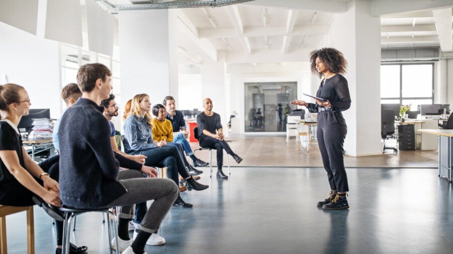 A young manager discusses digital training with her team