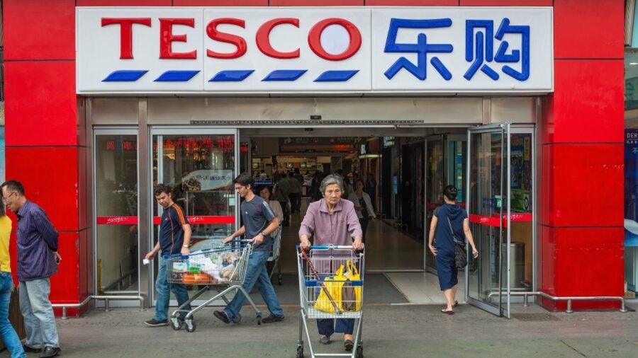 Shoppers at the entrance of a Tesco supermarket in Shanghai