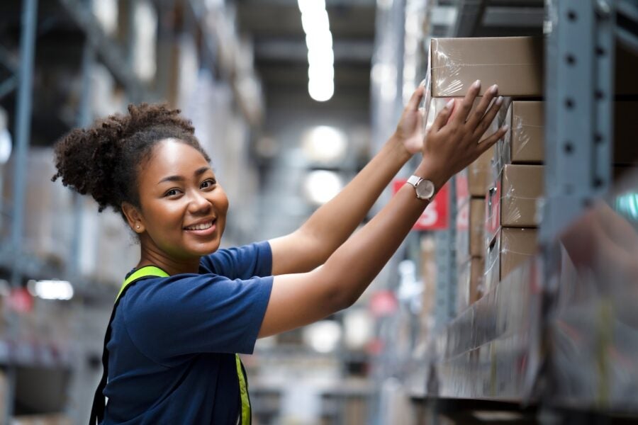 African,american,warehouse,worker,take,flat,box,from,shelf,in