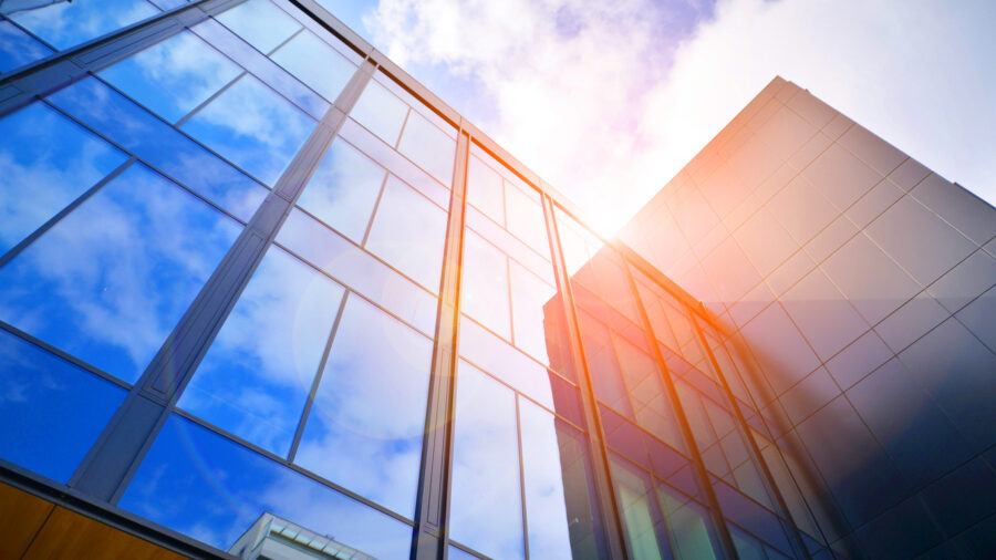 Glass Buildings With Cloudy Blue Sky Background. Perspective Wide Angle View To Steel Light Blue Background Of Glass.