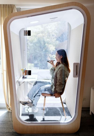 A Businesswoman Is Using A Phone Booth To Talk On The Phone In Her Office 1