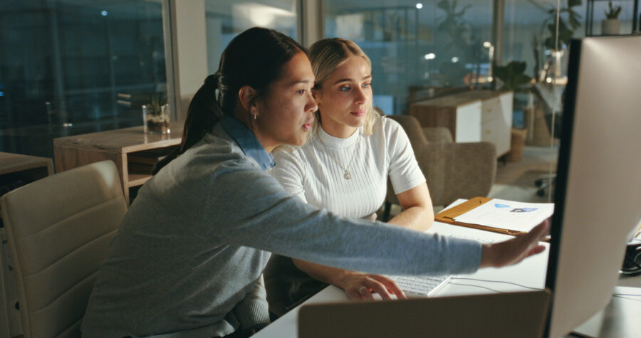 Teamwork, Computer And People Programming In The Office Doing Research On Laptop For Coding. Technology, Coders And Professional Women In Discussion Working On Project In Collaboration In Workplace.