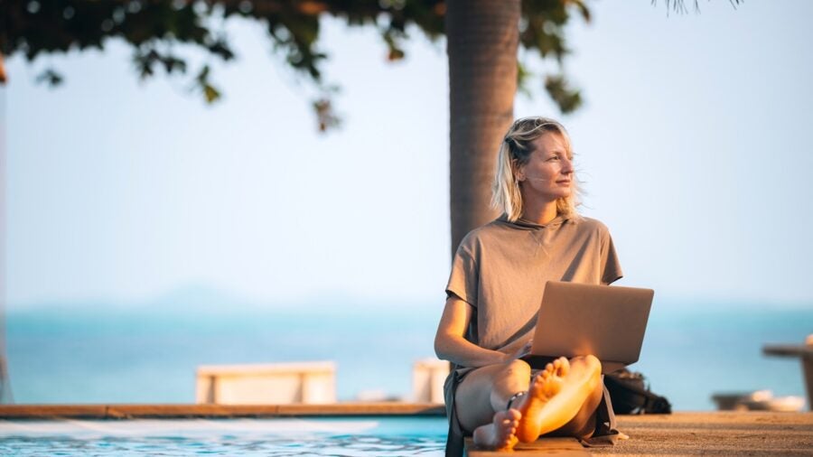 A Woman Works Remotely By The Pool