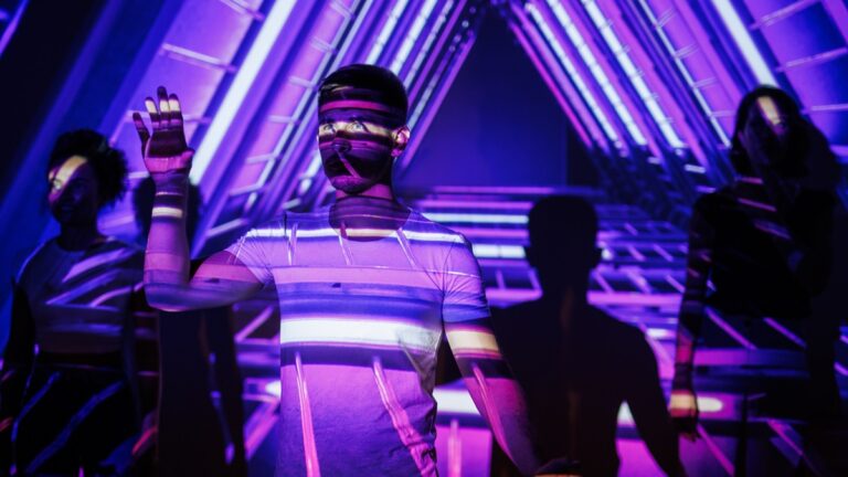 Person Amidst Neon Projections In A Futuristic Vibrant Environment With Glowing Patterns